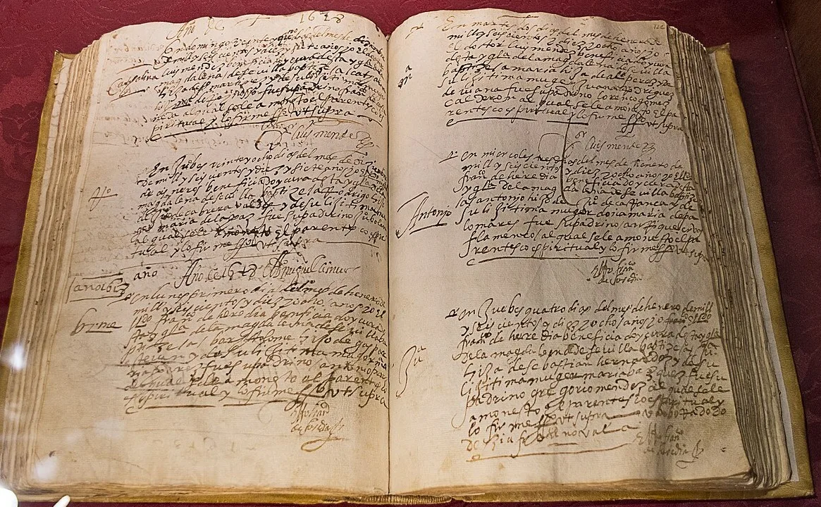 Libro de bautismos del siglo XVII abierto, escrito a mano